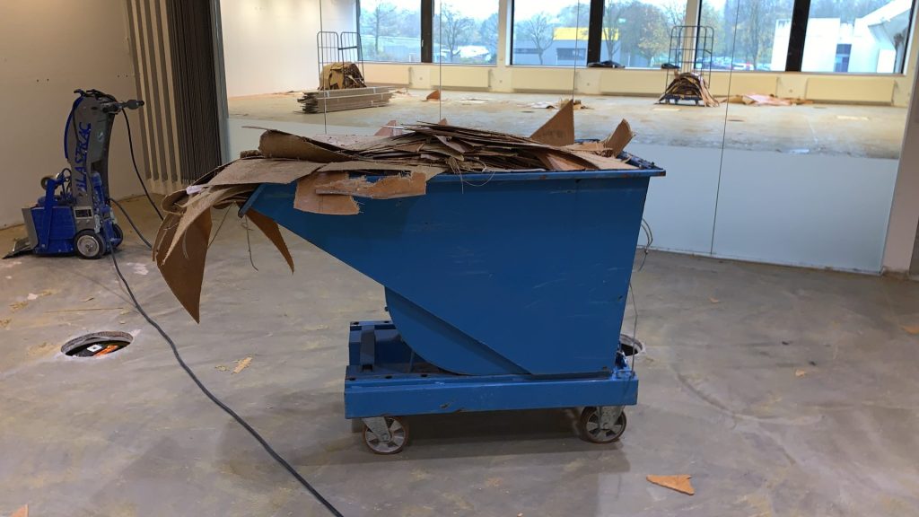 Blauer Container mit Pappe